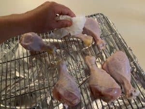 drying chicken legs with a paper towel