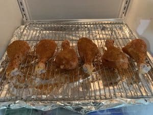 seasoned chicken legs dry brining in a refrigerator before smoking