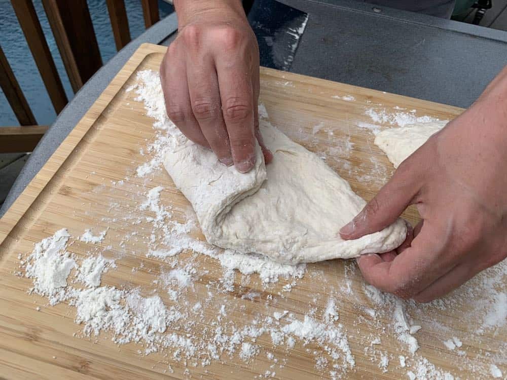 folding smoked pizza dough corners in