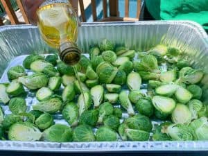 putting olive oil on brussel sprouts to smoke