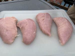 raw turkey tenderloins on a cutting board