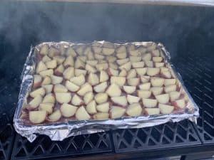 red potatoes smoking in smoker to make smoked mashed potatoes