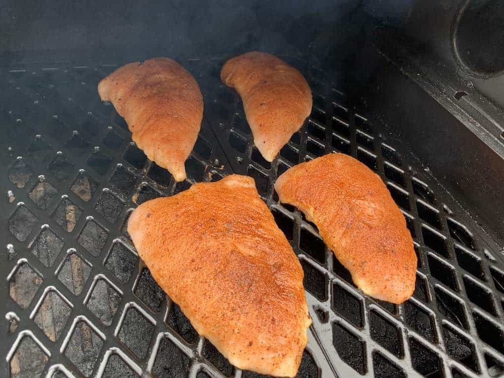 raw turkey tenderloins placed in a smoker to smoke