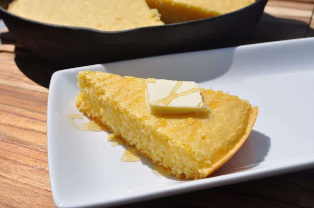 smoked cornbread slice with butter and honey drizzled