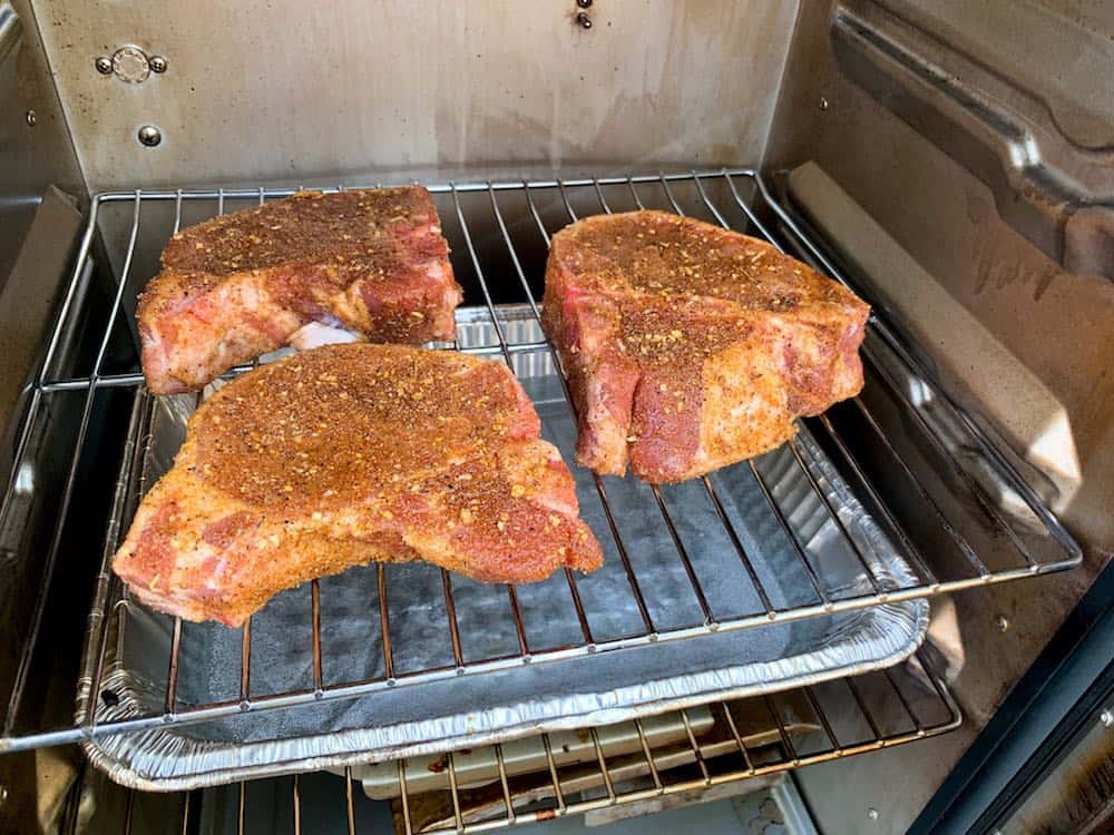 pork chops smoking in a masterbuilt electric smoker