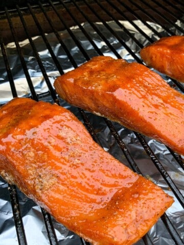 smoked salmon fillets on the grates of a traeger pellet grill