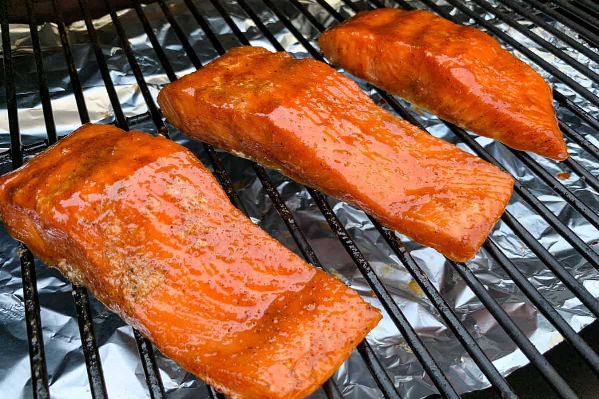 smoked salmon fillets on the grates of a traeger pellet grill