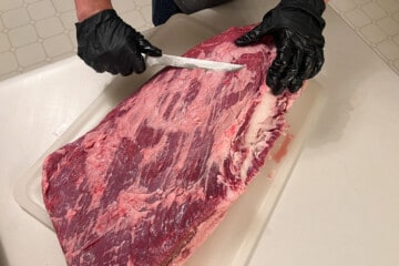 trimming a beef brisket with a knife