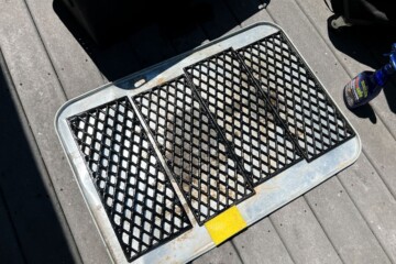 grill grates on an oil drip pan in the sun to dry