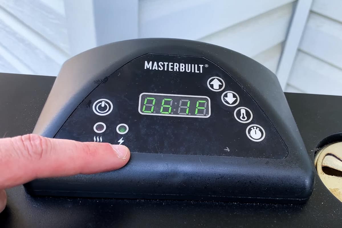 the control panel of a masterbuilt electric smoker showing the green light meaning the unit is plugged in but not heating