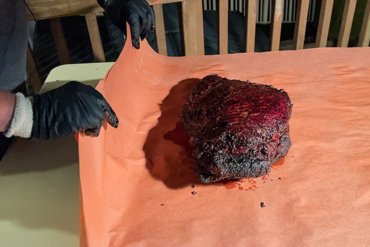 a beef brisket on a piece of butcher paper about to be wrapped