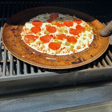 frozen pizza on a pizza pan on a pellet grill