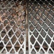 two grates of a pit boss pellet grill: one on the left is before cleaning and one on the right is after cleaning