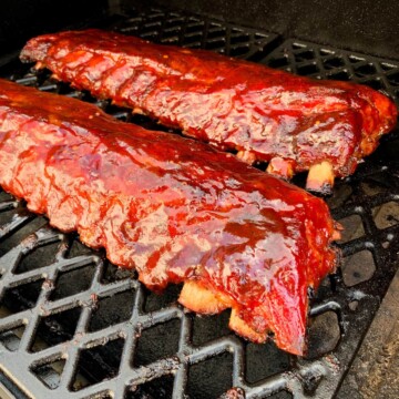 baby back ribs on the grates of a pit boss pellet grill