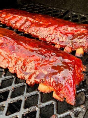 baby back ribs on the grates of a pit boss pellet grill