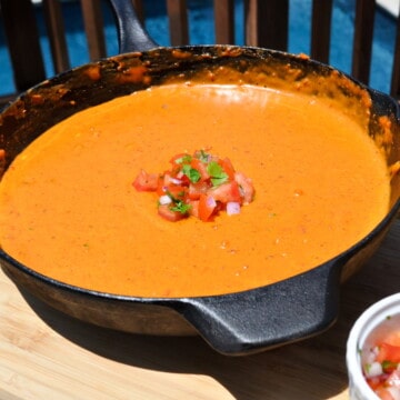 pit boss smoked queso in a cast iron skillet with pico de gallo on top