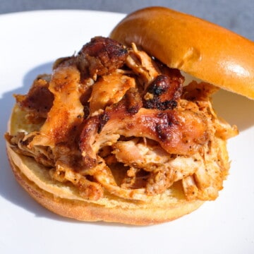 Smoked pulled chicken sandwich on a white plate