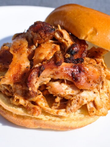 Smoked pulled chicken sandwich on a white plate