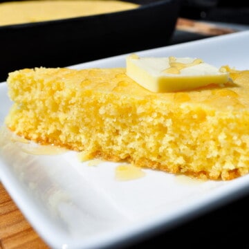 Smoked cornbread slice on a plate with butter and honey on top