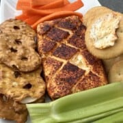 Smoked cream cheese on a cracker with pretzels and vegetables