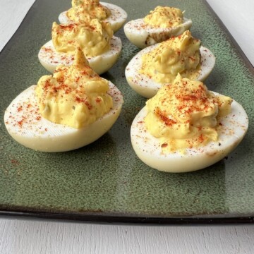 Smoked deviled eggs on a green platter