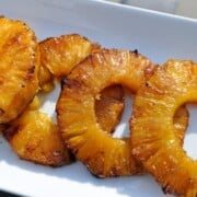 smoked pineapple rings on a white plate