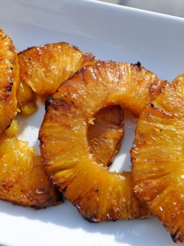 smoked pineapple rings on a white plate