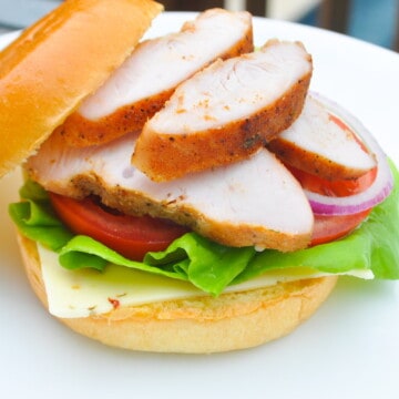 Smoked turkey sandwich on a white plate