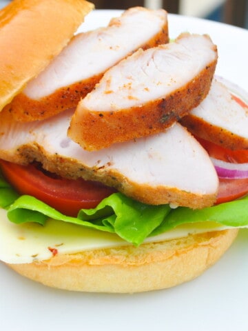 Smoked turkey sandwich on a white plate