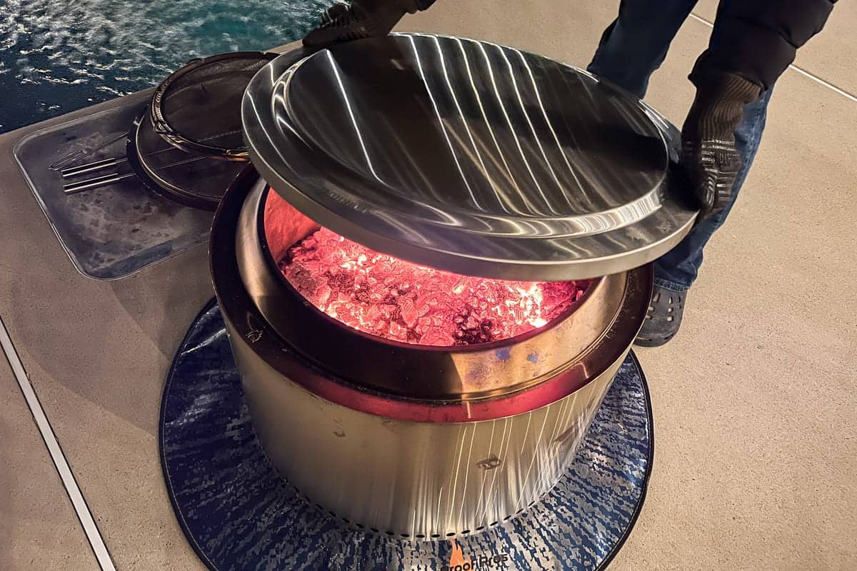 Placing the solo stove lid on top of the fire to snuff it out