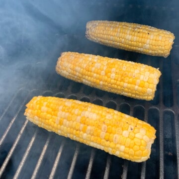 corn smoking on the grate of a treager pellet grill