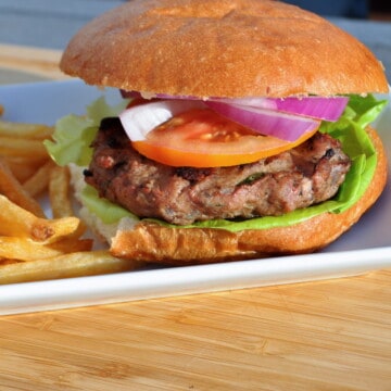 smoked turkey burger on a bun on a white plate