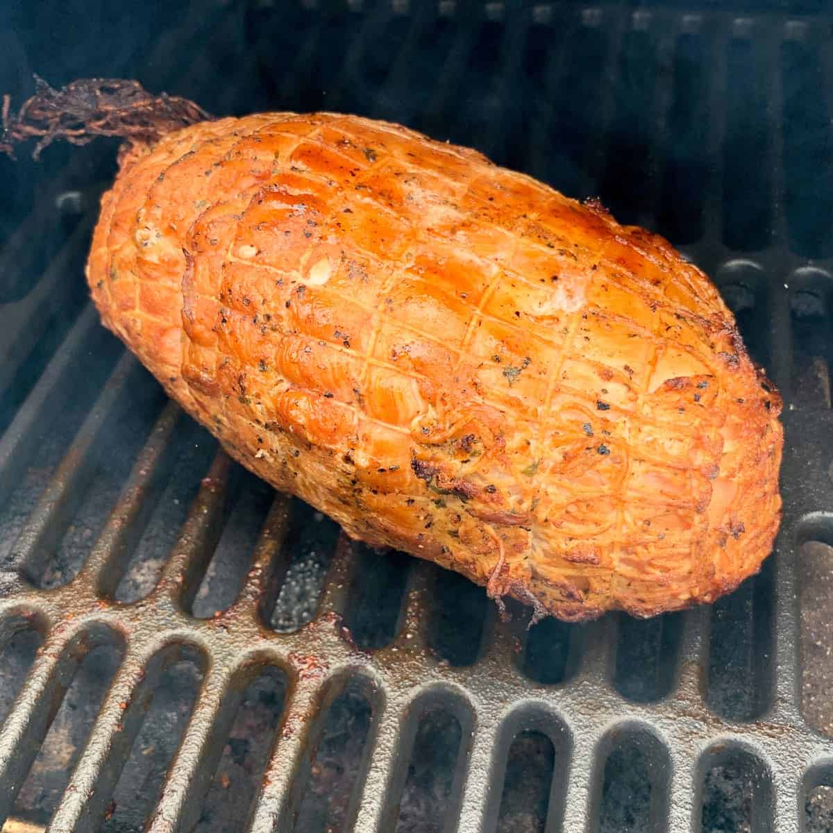 turkey breast roast on the grates of a traeger pellet grill