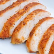 Smoked turkey tenderloins sliced on a white plate