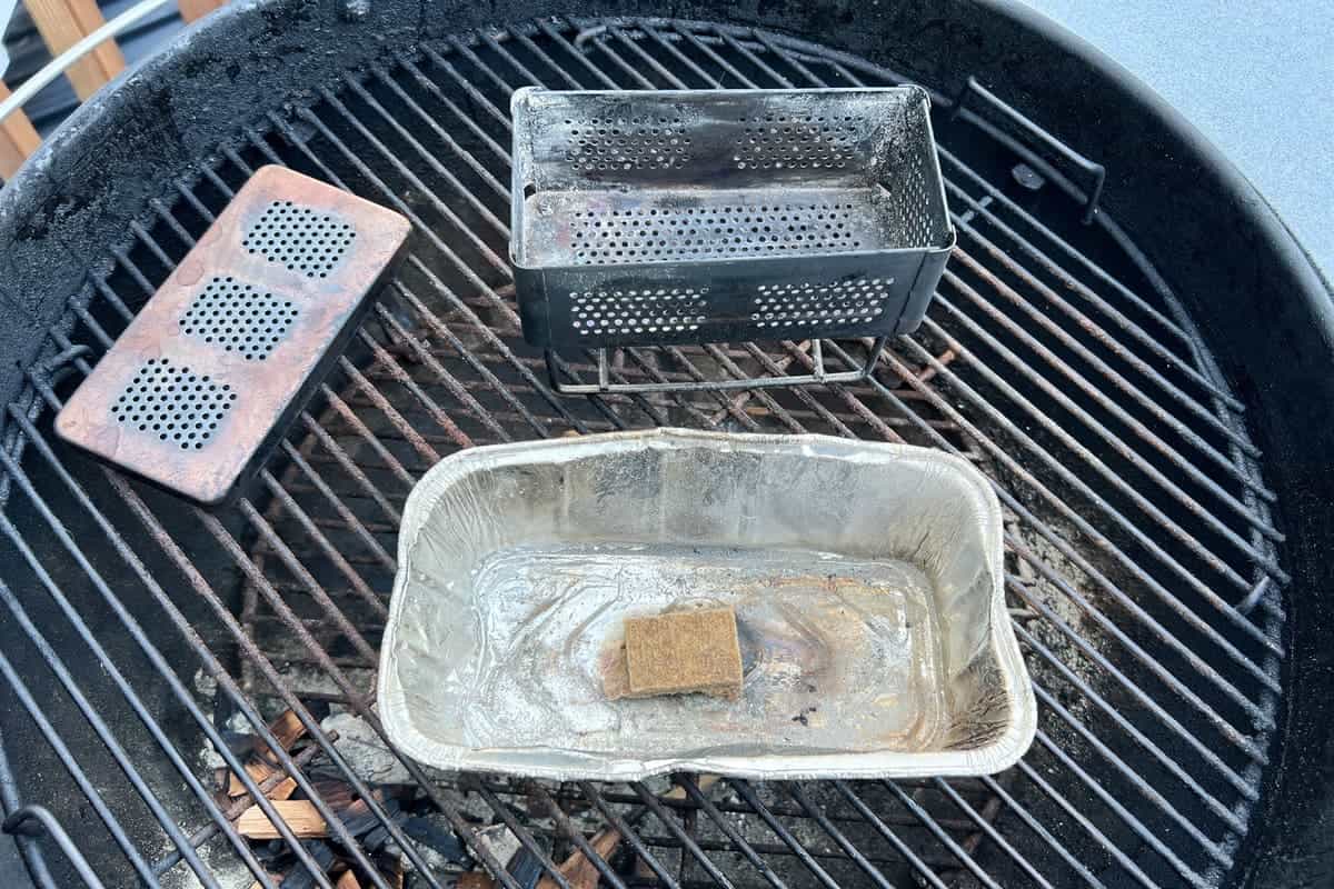 Firestarter cube in the bottom of an aluminum foil loaf pan on a charcoal grill