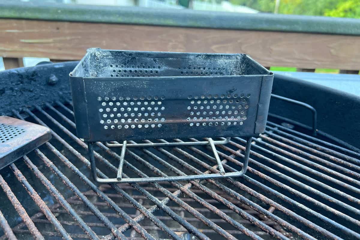 flip box smoker on top of the grates of a charcoal grill