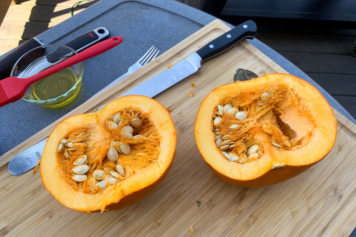 a cut open pie pumpkin revealing the seeds and pulp inside
