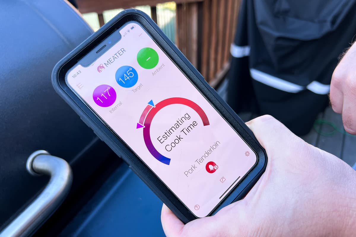 a smart phone showing the MEATER app with pork tenderloin selected showing the internal temperature and ambient temperature inside the grill