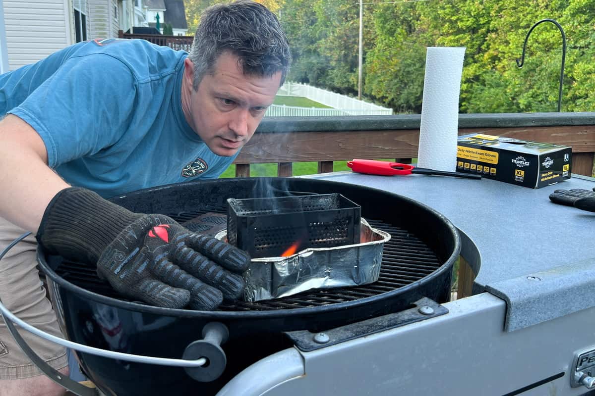 Mads looking at the smoker box with charcoal being ignited by the burning fire starter cube