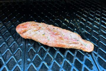a pork tenderloin on the grates of a pit boss pellet grill