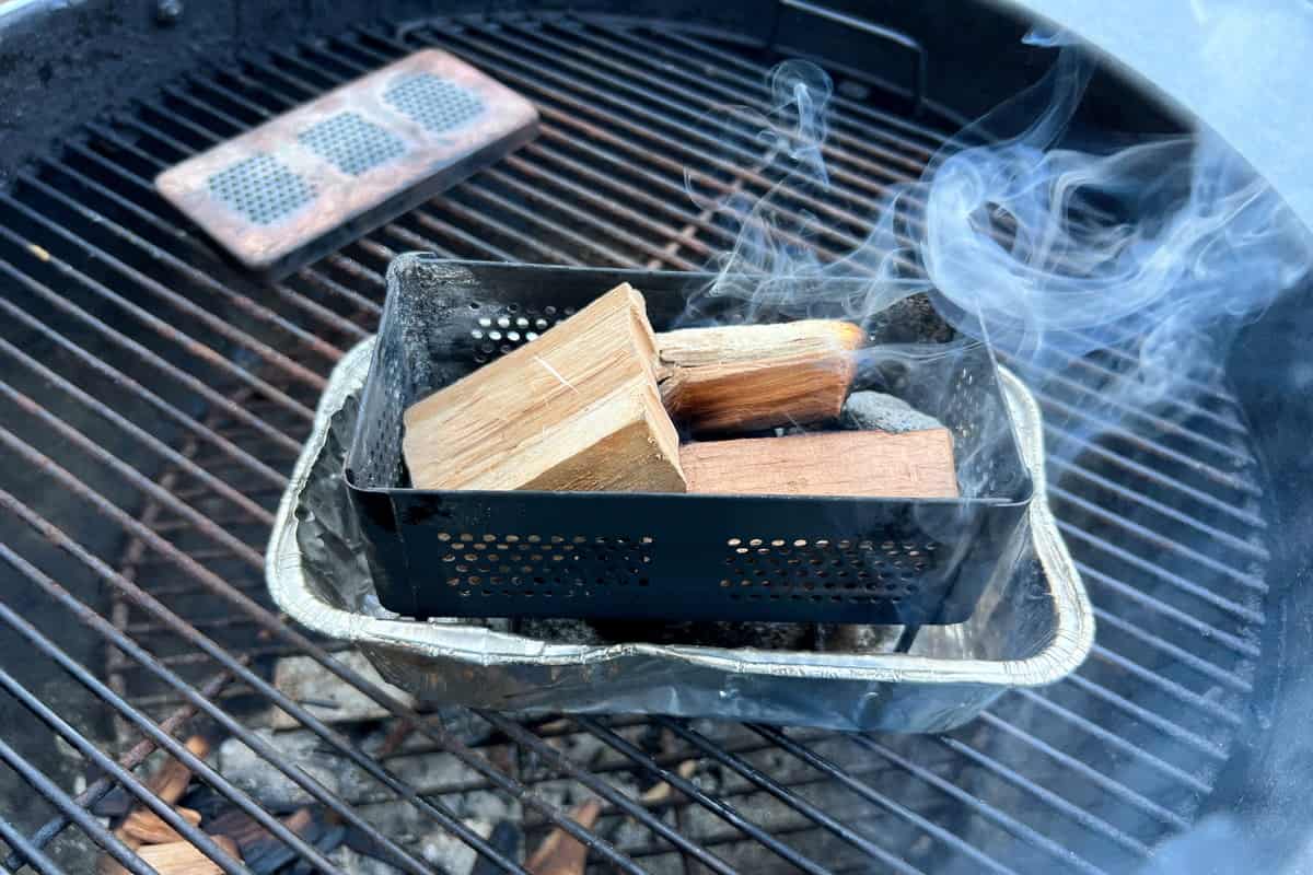 wood chunks on top of the lit charcoal in the smoker box