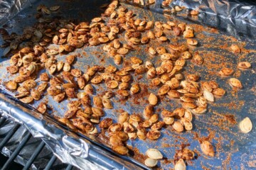 seasoned pumpkin seeds on a foil lined baking sheet