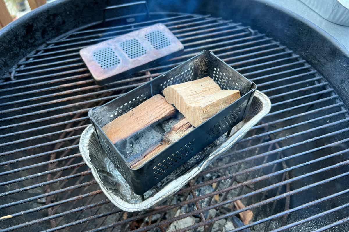 wood chunks in a firebox set inside an aluminum foil loaf pan