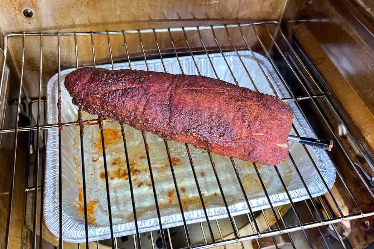 pork tenderloin partially cooked with a MEATER thermometer inserted through the side