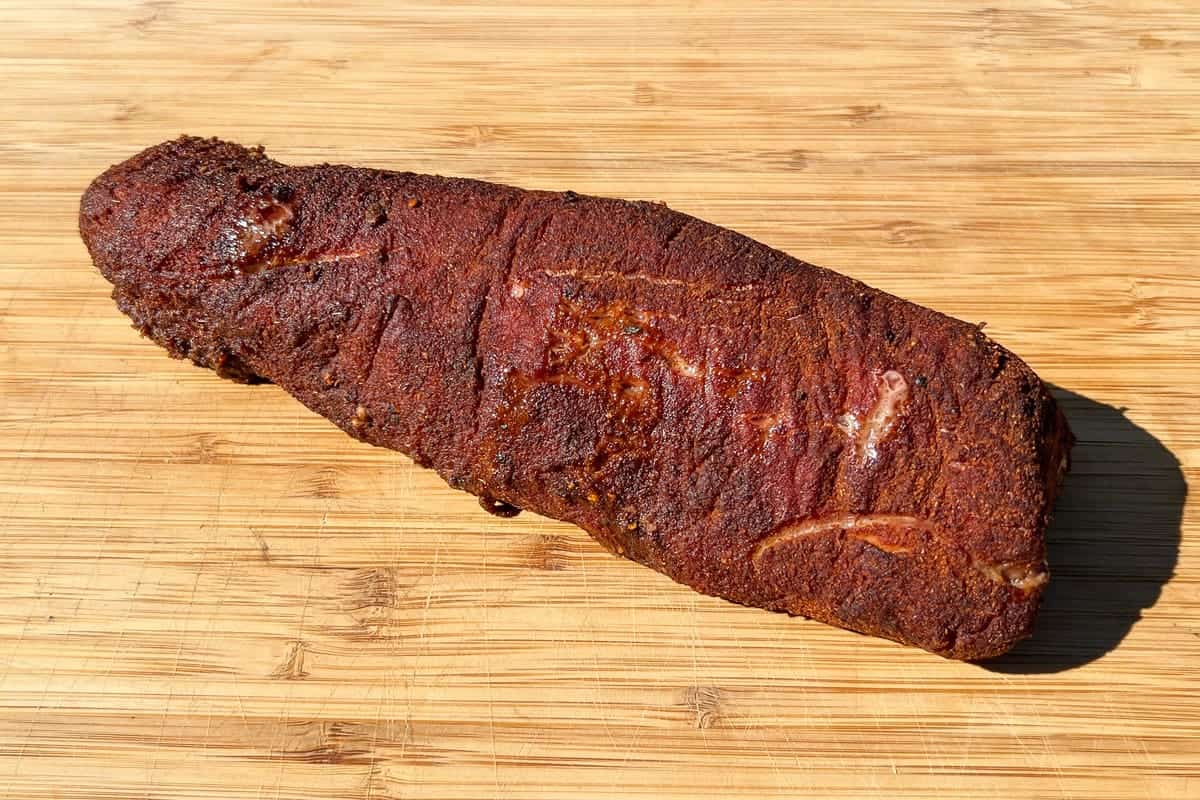 BBQ pork tenderloin resting on a cutting board