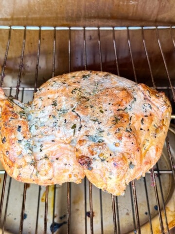 boneless turkey breast on the grates of a Masterbuilt smoker