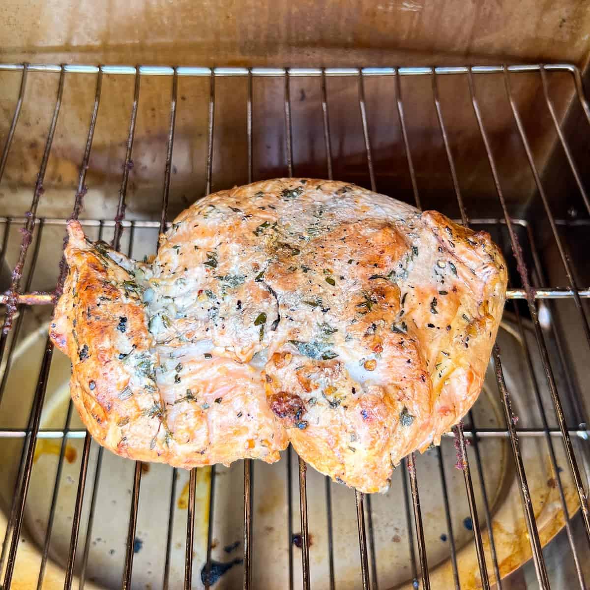 boneless turkey breast on the grates of a Masterbuilt smoker