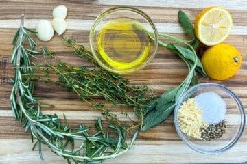 ingredients for garlic herb marinade on a wooden cutting board