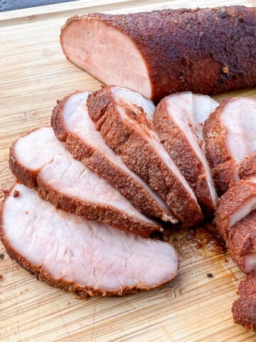 smoked pork tenderloin sliced on a cutting board