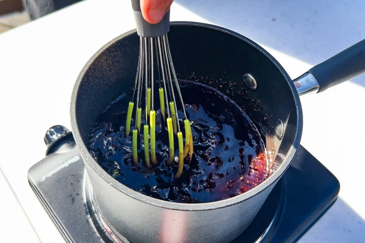 cherry glaze in a saucepan being whisked